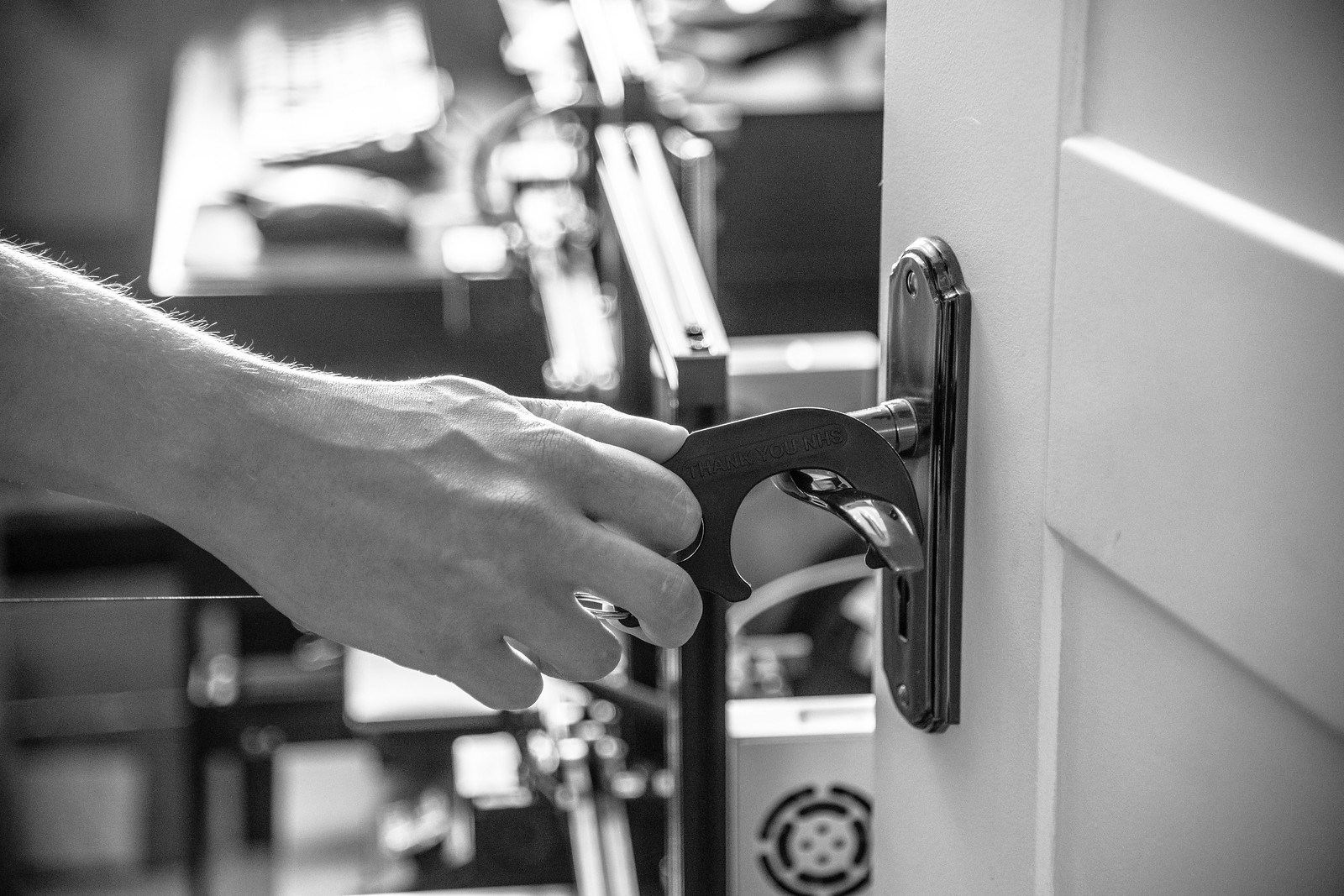 Black and white photo of hand and device opening door handle - copyright thisisjude_uk 2020