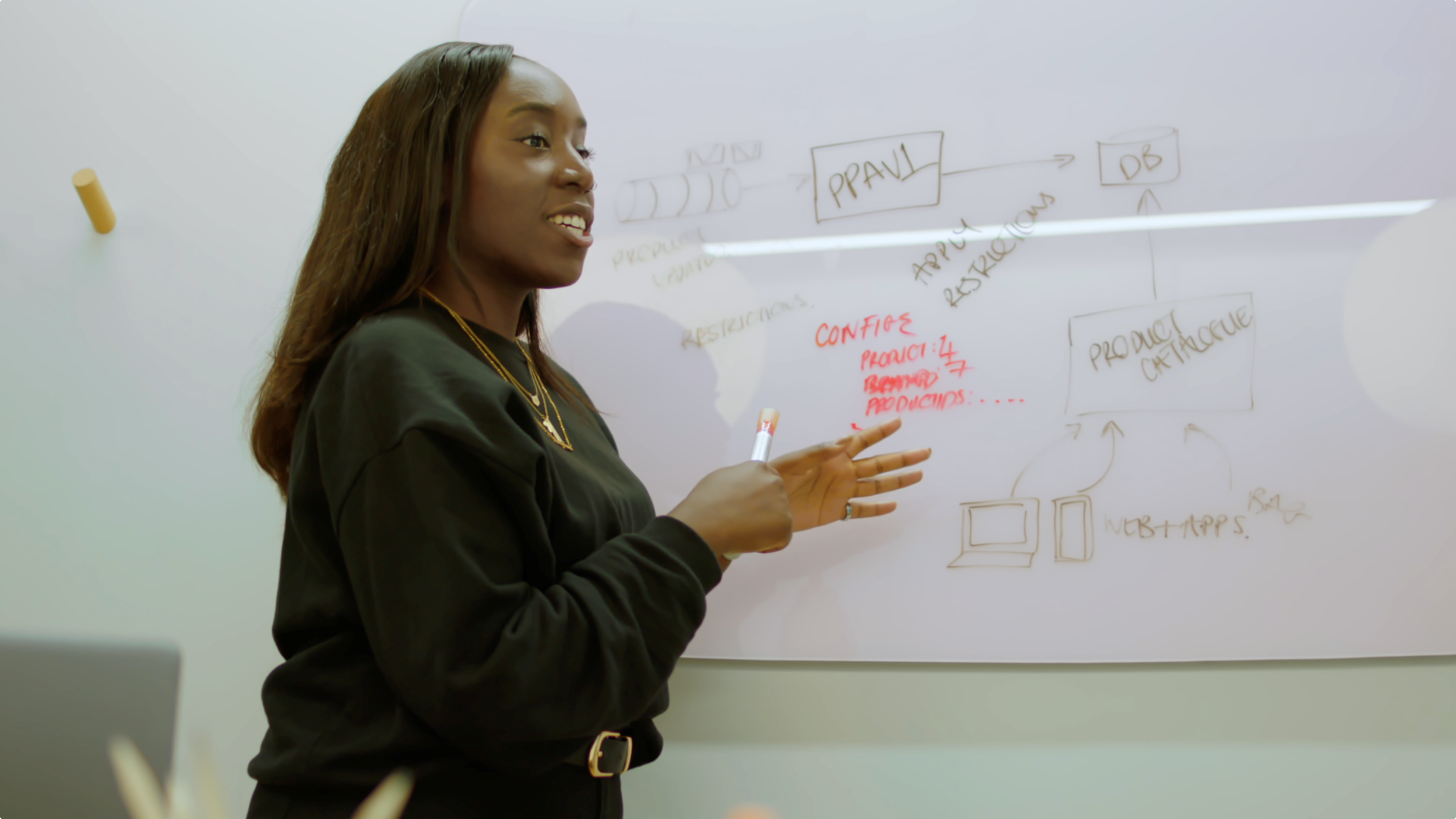 Black female software engineer presents at whiteboard © This is Engineering