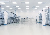 Team of researchers in sterile suits working in an industrial laboratory