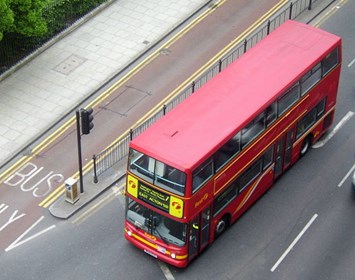 Aerial photo of a double-decker red bus at a traffic light
