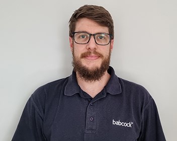 Man with glasses and beard, smiling.