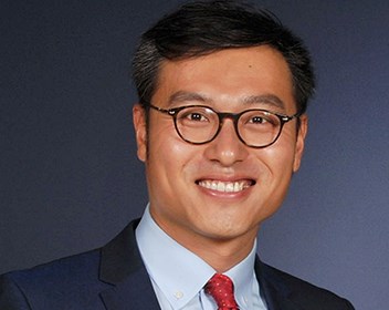 Smiling man wearing a blue suit and a red tie