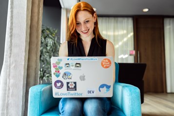 Female software engineer (ginger hair, jeans, black top) works on laptop ©This is Engineering